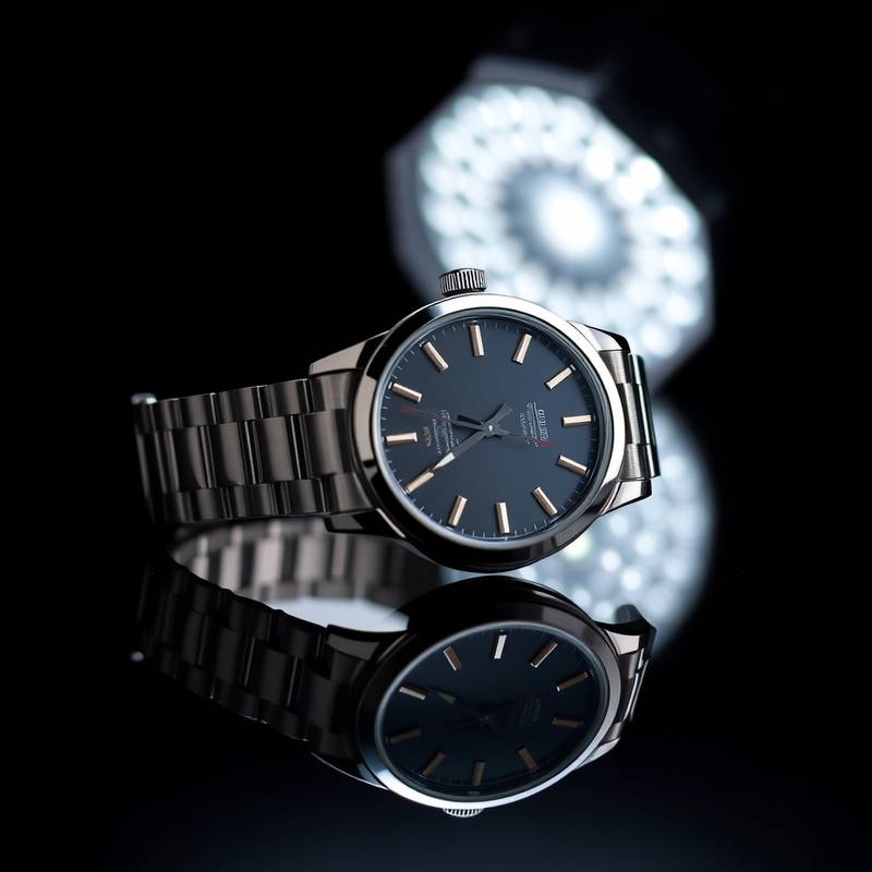 Eine professionelle Aufnahme einer eleganten Armbanduhr auf einem dunklen, reflektierenden Untergrund.